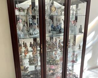 Lighted china cabinet full of Lladro, Hummels