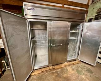 Working stainless steel commercial refrigerator: doors opened.