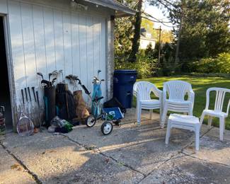 Lots of outdoor chairs and golf clubs.