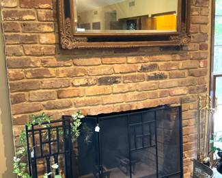 Large mirror; black fireplace screen; brass fire fender