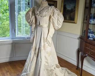 13.)  ca 1895 Bridal/Wedding Gown, Pearls, Lace, Train, Leg-o- Mutton sleeves.  Dress is slightly soiled at edge of train.  A few pearls lost in collar, bodice, and sleeves.  No underarm stains.  Inside stays to keep train pleated.  An occasional light stain.  Dress is in excellent condition.   Measures: Bodice:  shoulder to shoulder - 12",  Bust - 28",  Waist 20", Length 16".  Skirt:  Waist 18", Length 43", Length with train - 70".    $650.00  Sale:  $487.00