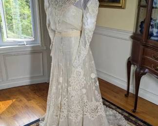 20)  ca 1900's Princess lace wedding gown.  There are a few stains on the lace but otherwise, the lace is in excellent condition.  The inner lining is shattering.   Measures:  shoulder to shoulder - 15",  Bust 30", Waist 24",  Length 59",  Length with train - 73".    $1300.00  Sale:  $975.00