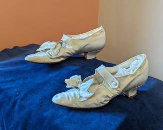 6.)  Antique Ivory Satin Wedding Shoes.  Front has satin bow and strap with button. Satin is in excellent condition.  Measures:  11 1/2" long x 3" wide.    $128.00  Sale:  $96.00
