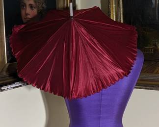 6.)  Lovely red polished cotton (?) parasol.  White carved wooden handle.  1 small pinhole in fabric.   Otherwise excellent condition.   $72.00