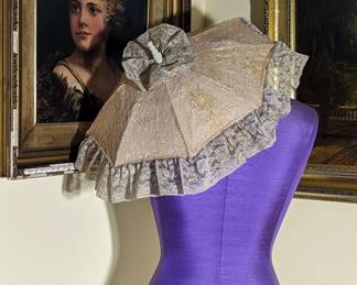 7.)  Alencon Lace parasol with pink fabric background.  A few stains to lace.  1 spoke has broken and caused a small hole at the break.  White wooden handle.  $65.00