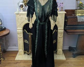 45.)  ca 1900 Green velvet 2 piece dress.  Bodice is boned with cording decoration.  Metal embroidery on net.  Beads and Bugle beads under top with metal embroidery.  Detachable collar.  Interior of bodice shattering.  The skirt has decorative cording and beautiful velvet covered buttons.  There are 3 tiny marks to the velvet and some giving of the under silk at the waist band.  Overall condition is excellent.  Measurements:  Top:  shoulder to shoulder - 14"  Bust - 28",  Length - 16".  Skirt:  Waist - 26 ", Length - 39", Total length - 55".  $680.00