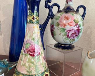 A pair of hand decorated antique pitchers