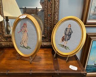 A pair of oval framed needlepoints