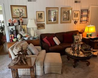 Leather couch in the background, white cloth chair on the left. The small round coffee table stays with the family.