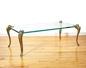 SPANISH GLASS AND BRASS LOW TABLE | Finely cast and chased brass cabriole legs affixed to a tempered glass top, marked "Made in Spain". - l. 50 x w. 26 x h. 17 in