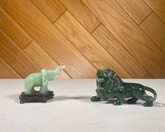(2PC) PAIR SMALL JADE FIGURINES | Small lion carved spinach jade figurine and smaller elephant figurine on a conforming wooden stand. - l. 5 x w. 1.5 x h. 2.5 in