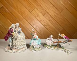 (3PC) COLONIAL LACE FIGURINES | Showing man courting woman in floral ball gown, a woman reading beside a tree, plus children on a see-saw. - l. 8 x w. 6.25 x h. 9.5 in (larger)