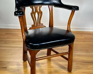 BLACK LEATHER LIBRARY ARMCHAIR | Curved back black leather armchair with studded border and carved wooden back. - l. 28 x w. 20 x h. 32 in