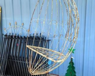 Swinging metal egg chair.  Metal fencing.
