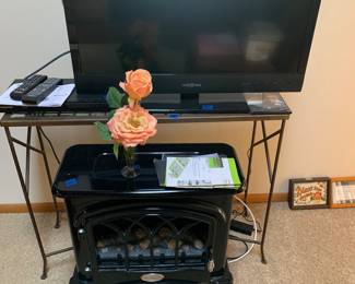Vintage-look heat stove, TV, narrow table.