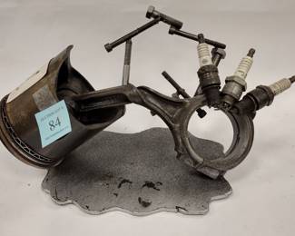 Automotive metal art sculpture made from a piston and spark plugs 