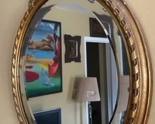 Oval antique giltwood - framed beveled mirror.