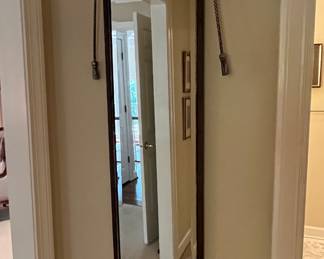 This mirror gives the appearance of hanging from a metal hoop, but in reality it hangs like a picture frame.  It is SUPER heavy and of high quality.
