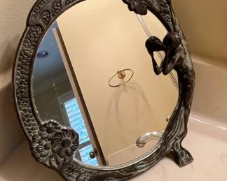 Look closely.  This is a metal mirror and to the right side the lady is looking at her own reflection.  This piece spoke to me!  If you have a spot for it, it would make for a great conversation piece.  It is also useful.