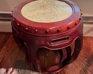 Teak stool with a delicate design on some sort of resin on the top.  A stand alone piece of artwork, or it could double as a plant stand.