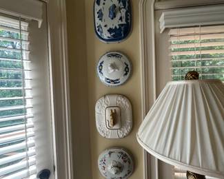 These are soup tureen lids.  What a clever idea for decor.  No doubt an interior decorator lived here.