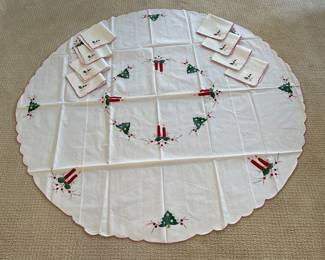 $25.00.   65” diameter.   Hand Stitched Round Christmas Table Cloth & 8 Napkins  excellent condition 