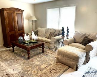 The living room contains a sofa and chair/ottoman by Bernhardt, metal/glass end tables, and an 8 x 10 wool Safavieh rug. 