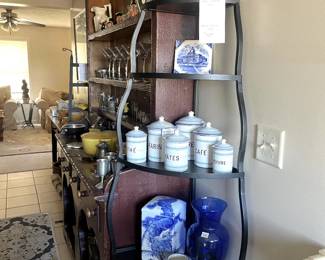 Heavy metal corner shelf with a set of french canisters and lots of blue and white. 