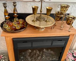 electric fireplace, acrylic grapes, brass cake stand, brass candleabra, brass goblets, set of 3 tortoise like votives