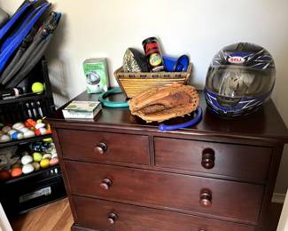 Pottery Barn dresser.  Dirtbike helmet.  Swimming flippers, baseball mit. 