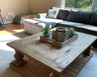 large wooden coffee table, decorative tray, candle holders, plants