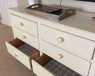 ivory wood chest of drawers, television, table lamp, decorative tray.