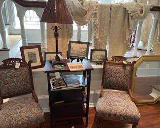Antique chairs, small bookshelf, draperies in the background