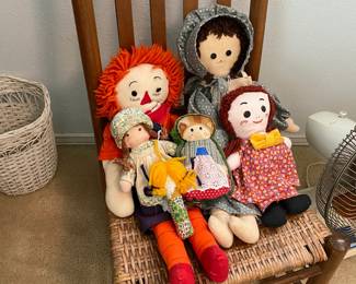 Antique rocker with rush seat with a collection of Rag Dolls