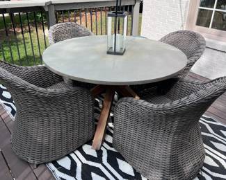 Grey all weather wicker chairs and wood table with all weather rug