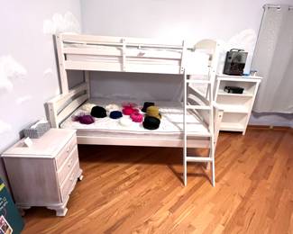 White bunk bed on top and full size bed on bottom with mattresses. Bookcase and nightstand. 