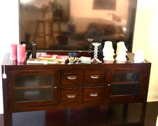 Larger television and Mahogany-coloured cabinet underneath which could serve many purposes