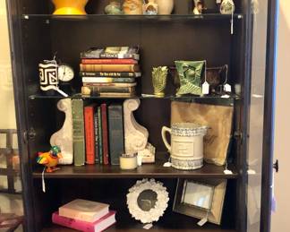 Glass front bookcase with many decorative items