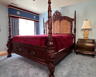 King size cherry throne bed with ornately carved crest headboard with canning (some areas of cane need repair as well as 2 small leaves on footboard) carved posts with lions head and paw feet on footboard, headboard is 7'6"H