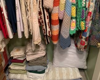 Multitude of quilts, afghans, and linens 