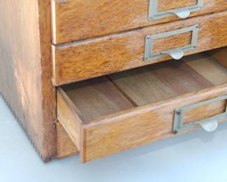 Drawer detail of vintage wooden 10-drawer flat file cabinet, drawer is divided in half, beautiful detail of paneling for the base of the drawer.