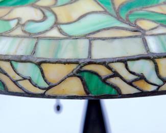 Detail of glass on antique art nouveau bronze table lamp with leaded glass shade