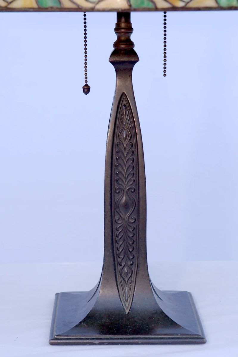 Detail of the base of the antique art nouveau bronze table lamp with with leaded glass shade