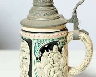 Handle right view of vintage ceramic German beer stein with pewter lid (#6), inscription reads, "Trinkt Und Singt Woman Da Lass Woman Dich Ruhig Nieder"
