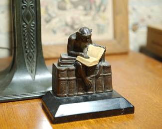 Delightful book-end of a monkey reading on a row of books 