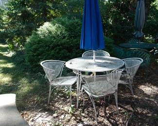 White wrought iron round patio table and 4 chairs with an umbrella