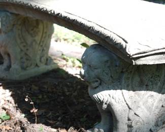 Closer detail of curved concrete bench with lion legs