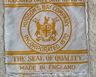 Tag detail of Hudson's Bay Point blanket, cream with black, yellow, red, and green stripes