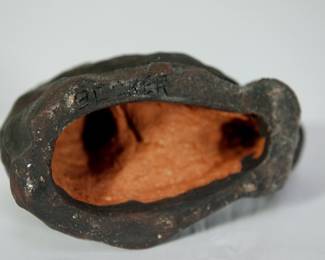 Bottom of Mid Century studio pottery sculpture of a man holding a child, showing artist signature, Becker.
