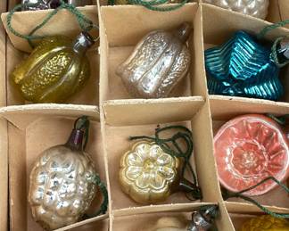 Detail of lovely antique glass Christmas tree ornaments in silver, gold, white, blue, and pink.